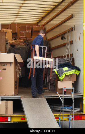 Déménageurs transportant dans un camion de meubles. Banque D'Images