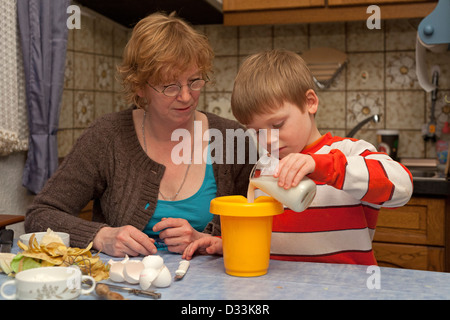 Une mère et son jeune fils préparer un repas ensemble Banque D'Images