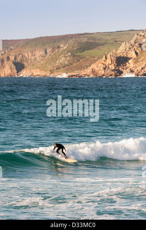 Surf, Cornouailles - Un surfeur solitaire chevauchant une vague à Sennen Cove à Cornouailles, Angleterre, Royaume-Uni Banque D'Images