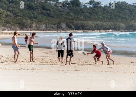 Les jeunes gens jouant avec une balle sur le cylindre Beach sur l'Île Stradbroke-nord au Queensland, Australie Banque D'Images