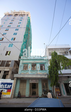 1930 bâtiment indien dominé par de nouveaux hi-rise construction, Dar es Salaam, Tanzanie. Banque D'Images