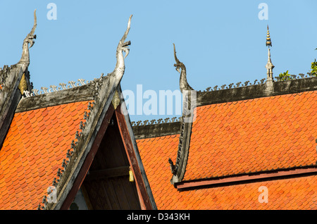 Détail du toit du Wat Sensoukharam Luang Prabang Laos // LUANG PRABANG, Laos — les tuiles orange du toit à plusieurs niveaux du Wat Sensoukharam présentent l'architecture traditionnelle du temple bouddhiste lao à Luang Prabang. Les pointes du toit sont décorées de chofah, des embouts ornementaux représentant Garuda, la créature mythique mi-homme et mi-oiseau des traditions hindoue et bouddhiste qui sert de monture au Dieu hindou Vishnu. Le Wat Sensoukharam fait partie des nombreux temples bouddhistes qui ont contribué à la désignation de Luang Prabang comme site du patrimoine mondial de l'UNESCO. L'ancienne capitale royale, située au conflu Banque D'Images