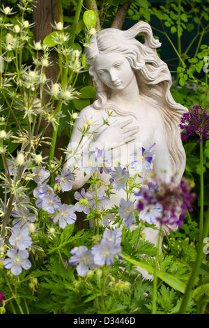 Statue femme au lit avec Géranium Splish Splash, Eryngium, Allium. Banque D'Images