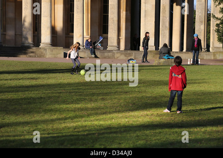 Garçon et fille (Cousins) à jouer au football à la salle des pompes Pittville Pleasure Gardens Cheltenham GLOUCESTERSHIRE Angleterre Banque D'Images