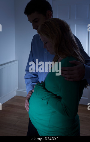 Jeune femme enceinte et l'homme qui se profile à la maison. Banque D'Images