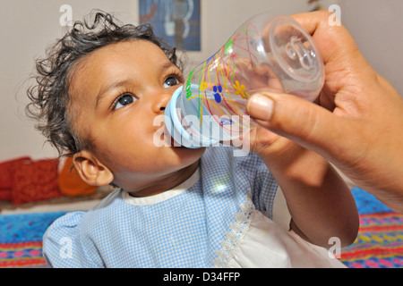 Bébé fille indienne de l'eau potable à partir d'une bouteille de bébé Banque D'Images