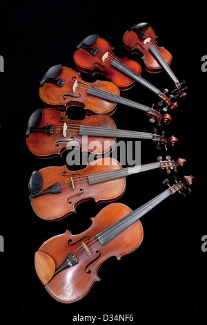 Différentes tailles de violons sur fond noir Banque D'Images