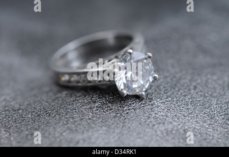 Bague à diamants sur fond de cuir gris élégant Banque D'Images