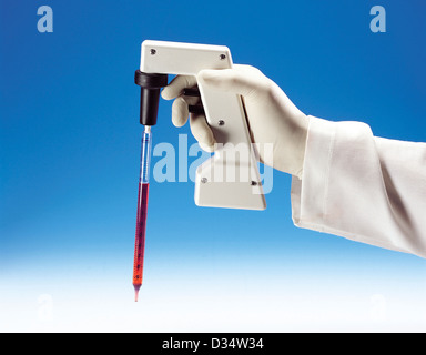Gloved Hand Holding Pipette Banque D'Images
