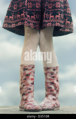 Une fille en wellies sur une table Banque D'Images