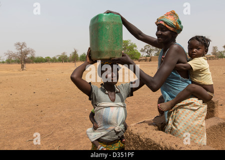 Yako, Burkina Faso, Mai 2012 : Les femmes aller chercher de l'eau dans le village de forage. Banque D'Images