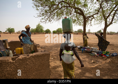 Yako, Burkina Faso, Mai 2012 : Les femmes aller chercher de l'eau dans le village de forage. Banque D'Images