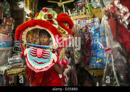 10 février 2013 - Bangkok, Thaïlande - Un Lion Dancer dans une échoppe de marché sur le Nouvel An chinois dans le quartier chinois de la section de Bangkok. Les propriétaires de boutiques invitent souvent les danseurs en Lion boutiques sur la nouvelle année à la danse pour une nouvelle année prospère. Ils ont ensuite faire un don à la troupe de danse du lion. Bangkok a une grande population d'émigrants chinois, dont la plupart se sont installés en Thaïlande au xviiie et xixe siècles. Le chinois, ou Nouvel An lunaire, est célébrée avec des feux d'artifice et défilés dans les communautés chinoises à travers la Thaïlande. L'année à venir sera la ''année du serpent'' dans le zodiaque chinois. (Cre Banque D'Images