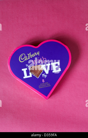 Boîte en forme de coeur avec l'amour de Cadbury 8 beau petit chocolats avec praliné noisette isolé sur fond rose - cadeau idéal pour la Saint-Valentin Banque D'Images