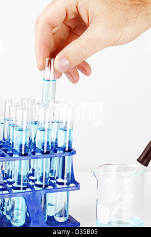 Chimiste ou autre scientifique et chercheur de prendre un tube à essai rempli de liquide bleu ou chimique, grande science historique. Banque D'Images