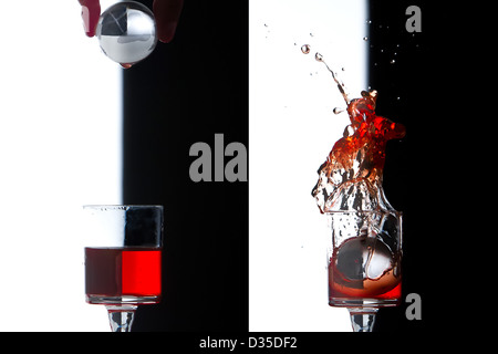 Verre, cristal Splash world tombant sur verre rouge, studio shot Banque D'Images