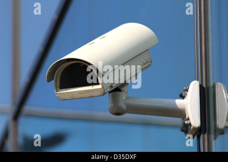 Caméra CCTV de sécurité blanc sur la façade en verre Banque D'Images