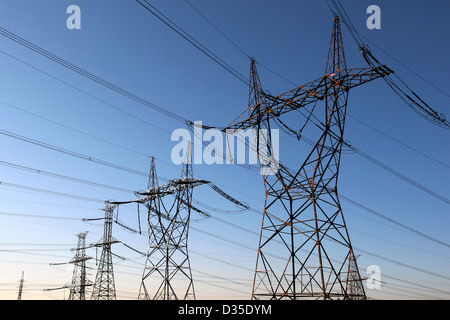 Électrique haute tension tours alignées Banque D'Images