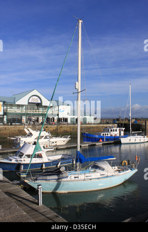 Vue sur les yachts et autres petits bateaux amarrés dans le port de plaisance par Freeport shopping centre à Fleetwood, Lancashire, Angleterre, Royaume-Uni Banque D'Images