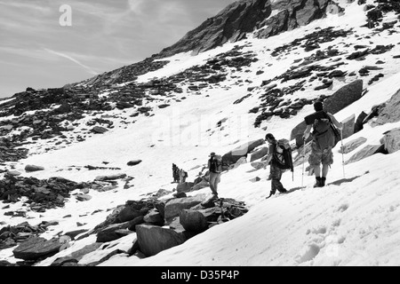 Les randonneurs marche sur piste couverte de neige alpine dans Herbetet Mountain, Parc National du Gran Paradiso, Graian Alps - Italie Banque D'Images