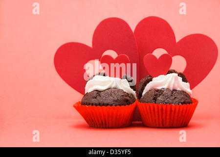 Deux valentines cupcakes avec quatre décorations coeur Banque D'Images
