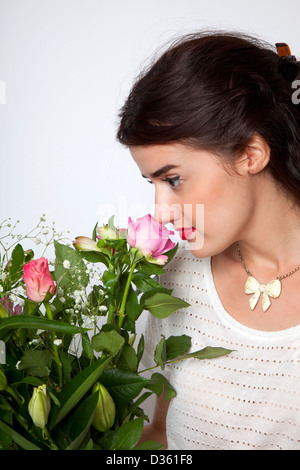 Woman Smelling Rose sur Bouquet de fleurs Banque D'Images