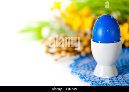 Composition de Pâques avec des oeufs bleu, chatons et fleurs de printemps sur le napperon en crochet sur fond blanc. Peint des oeufs décorés à la main, Banque D'Images