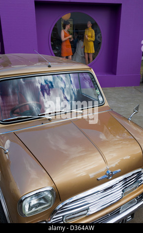 1960 scène re-enactment avec une Morris Mini Cooper S et filles dansant dans la fenêtre. 2012 Goodwood Revival, Sussex, UK. Banque D'Images