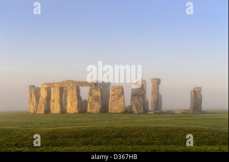 Stonehenge par la brume au lever du soleil Banque D'Images