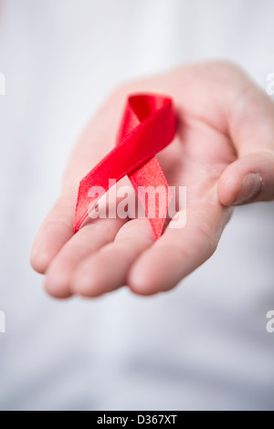 Man holding out Red Ribbon de sensibilisation au sida Banque D'Images