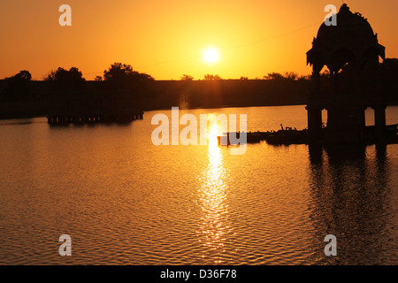 Lever du soleil à Gadi Sagar Lake avec silhouette d'un dôme au milieu, Rajasthan Inde Banque D'Images