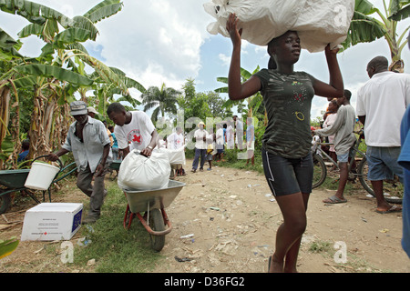 Léogâne, Haïti, une femme cargaisons auxiliaire transporté sur la tête Banque D'Images