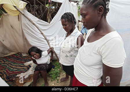 Léogâne, Haïti, entouré par d'autres femme désespérée dans un camp de réfugiés Banque D'Images