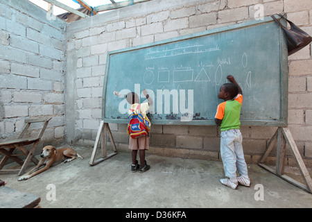 Léogâne, Haïti, les enfants dessiner sur un tableau noir dans la salle de classe Banque D'Images