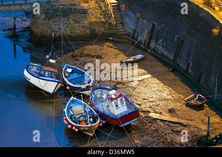 Les bateaux de pêche amarrés à Staithes, après la tombée de la nuit. Banque D'Images