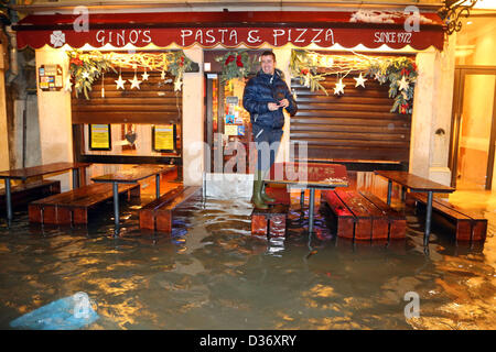 Venise, Italie. 12 février 2013. Après une journée de neige qui a fermé l'aéroport Marco Polo, les voyageurs forcés de passer une autre nuit à Venise est revenu pour trouver le moyen de leurs hôtels inondés comme les eaux du Grand Canal a augmenté de presque un mètre sur l'inondation de la marée haute. Crédit : Paul Brown / Alamy Live News Banque D'Images