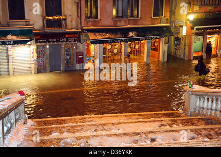 Venise, Italie. 12 février 2013. Après une journée de neige qui a fermé l'aéroport Marco Polo, les voyageurs forcés de passer une autre nuit à Venise est revenu pour trouver le moyen de leurs hôtels inondés comme les eaux du Grand Canal a augmenté de presque un mètre sur l'inondation de la marée haute. Crédit : Paul Brown / Alamy Live News Banque D'Images