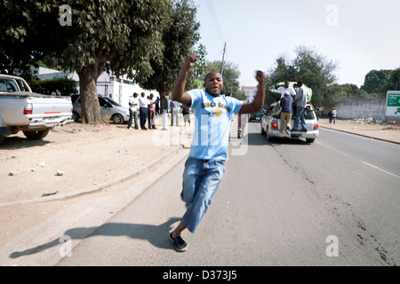 Une partisan de le nouveau président Michael Sata fonctionne sur une route dans le centre de Lusaka Banque D'Images