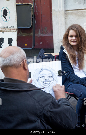 Dessin d'un caricaturiste une jeune femme à la Place du Tertre, le traditionnel repas de l'artiste à Montmartre, Paris. Banque D'Images