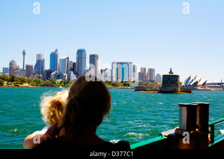 Une femme et un jeune enfant voir le Sydney skyline à partir d'un bateau sur une journée ensoleillée à partir de Sydney à bord du ferry à l'approche de Manly. Banque D'Images