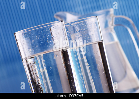 La composition avec deux verres d'eau sur fond bleu Banque D'Images