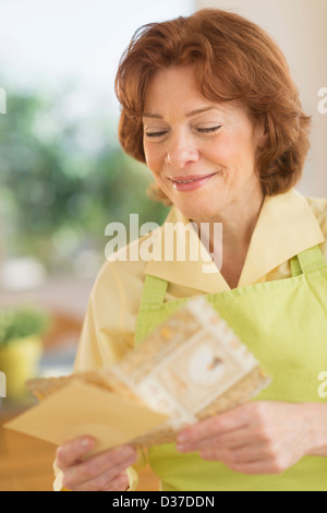 USA, New Jersey, Jersey City, Senior woman reading carte de souhaits Banque D'Images