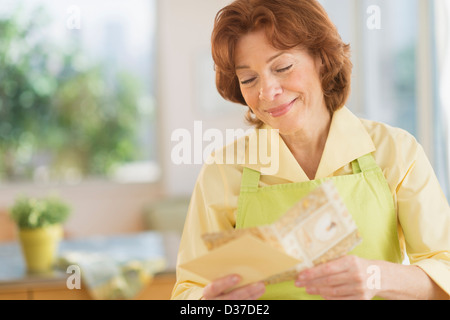 USA, New Jersey, Jersey City, Senior woman reading carte de souhaits Banque D'Images