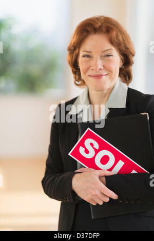 USA, New Jersey, Jersey City, Portrait de femme d'holding sold sign Banque D'Images