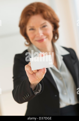 USA, New Jersey, Jersey City, Portrait of businesswoman holding blank business card Banque D'Images