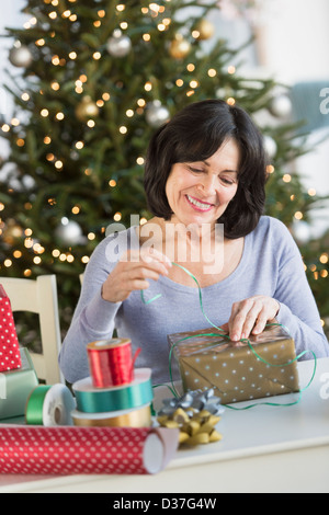 USA, New Jersey, Jersey City, Senior woman wrapping christmas gifts Banque D'Images