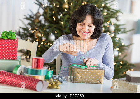 USA, New Jersey, Jersey City, Senior woman wrapping christmas gifts Banque D'Images