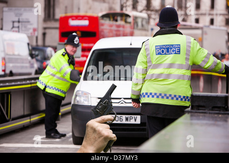 Barrières de police mis en place autour de la Maison du Parlement à Londres à l'abri de véhicule ou les kamikazes, et une arme à la main. Banque D'Images