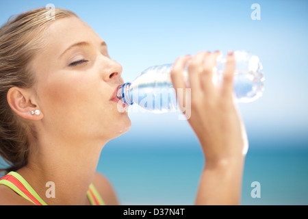 Woman drinking water bottle outdoors Banque D'Images