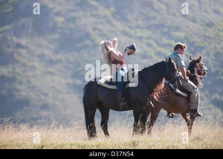 Couple riding horses in rural landscape Banque D'Images